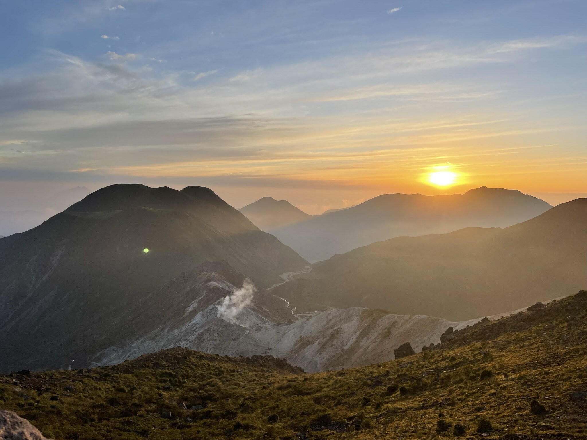 山頂から望む朝日と山々の風景
